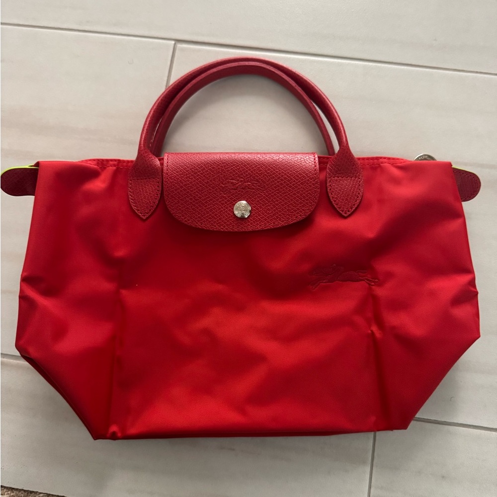 Longchamp Le Pliage recycled canvas top handle bag in the color ‘tomato’